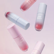 ProtoClinical k-beauty [TOO COOL FOR SCHOOL] Dew Blurry Tint 4g (10 Colors) upright pink lip tint bottle beside stacked soft sponge props on a pale studio background