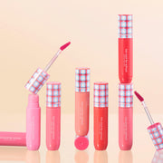 ProtoClinical k-beauty [TOO COOL FOR SCHOOL] Glossy Blaster Tint 3.4g (9colors) set with upright pink and coral lip tint tubes, plaid caps, and two open applicators on a peach background