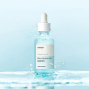 ProtoClinical k-beauty [MANYO FACTORY] Micro Hyaluronic Essence 50ml shown as an abstract pale blue graphic panel with a darker lower-center band on an off-white background.