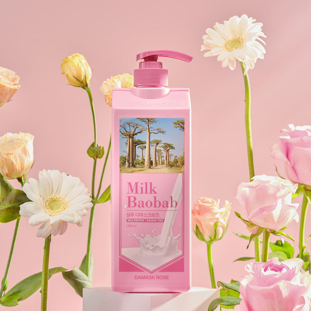 ProtoClinical k-beauty BIOKLASSE MILK BAOBAB Hair Shampoo 1000ml #Damask Rose single upright rose-pink shampoo bottle centered on a white background with pale aqua side accents.