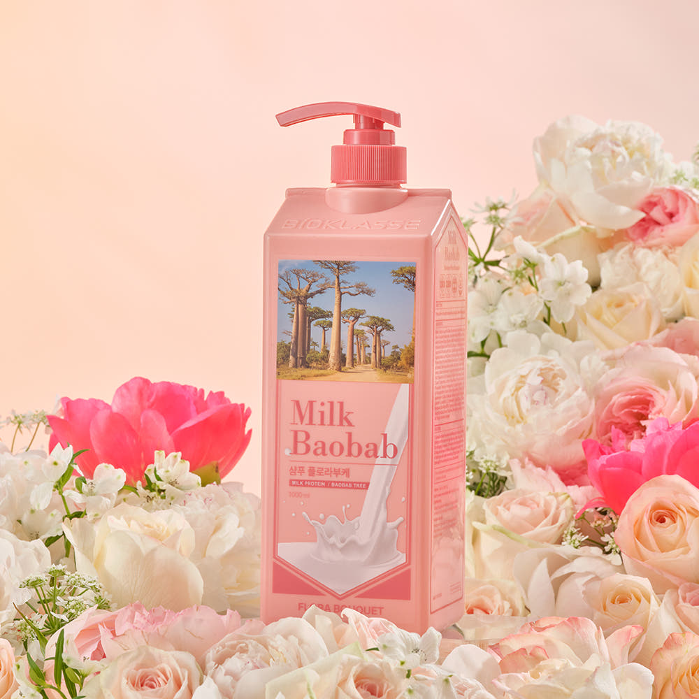 ProtoClinical k-beauty BIOKLASSE MILK BAOBAB Hair Shampoo 1000ml #Flora Bouquet single upright pink shampoo bottle centered on a peach background with warm cream side tones.