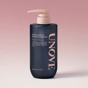 ProtoClinical k-beauty UNOVE DEEP DAMAGE REPAIR SHAMPOO 500ml #Sweet Breeze single upright dark shampoo bottle centered on a soft pink background.