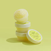 ProtoClinical k-beauty SKINFOOD Lemon Dill Butter Food Mask Lip Balm 21ml single olive lip balm package angled diagonally on a white background with soft yellow and pink shading