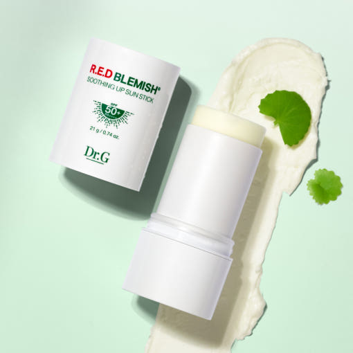 ProtoClinical k-beauty Dr.G RED BLEMISH Soothing Up Sun Stick SPF50+ PA++++ 21g open white sun stick and cap angled beside a cream swipe with two green leaf accents on a mint background