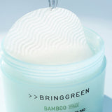 ProtoClinical k-beauty cosmetic packaging in soft beige tones on a pale blue and aqua background.