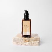 ProtoClinical k-beauty soft brown beauty product silhouette centered between pale blue and peach accents on a light background.