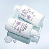 ProtoClinical k-beauty APLB Collagen EGF Peptide Body Lotion 300ml shown as two white pump bottles angled on a glossy pale blue surface with white lotion drops