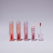 ProtoClinical k-beauty ETUDE Over Glowy Tint 3g #Not Bad single glossy pink lip tint tube with a silver cap, centered upright on a pale peach studio background