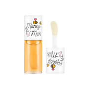 ProtoClinical k-beauty A'pieu Honey & Milk Lip Oil 5g (3-type) clear lip oil bottle with a white cap beside a doe-foot applicator on a white background