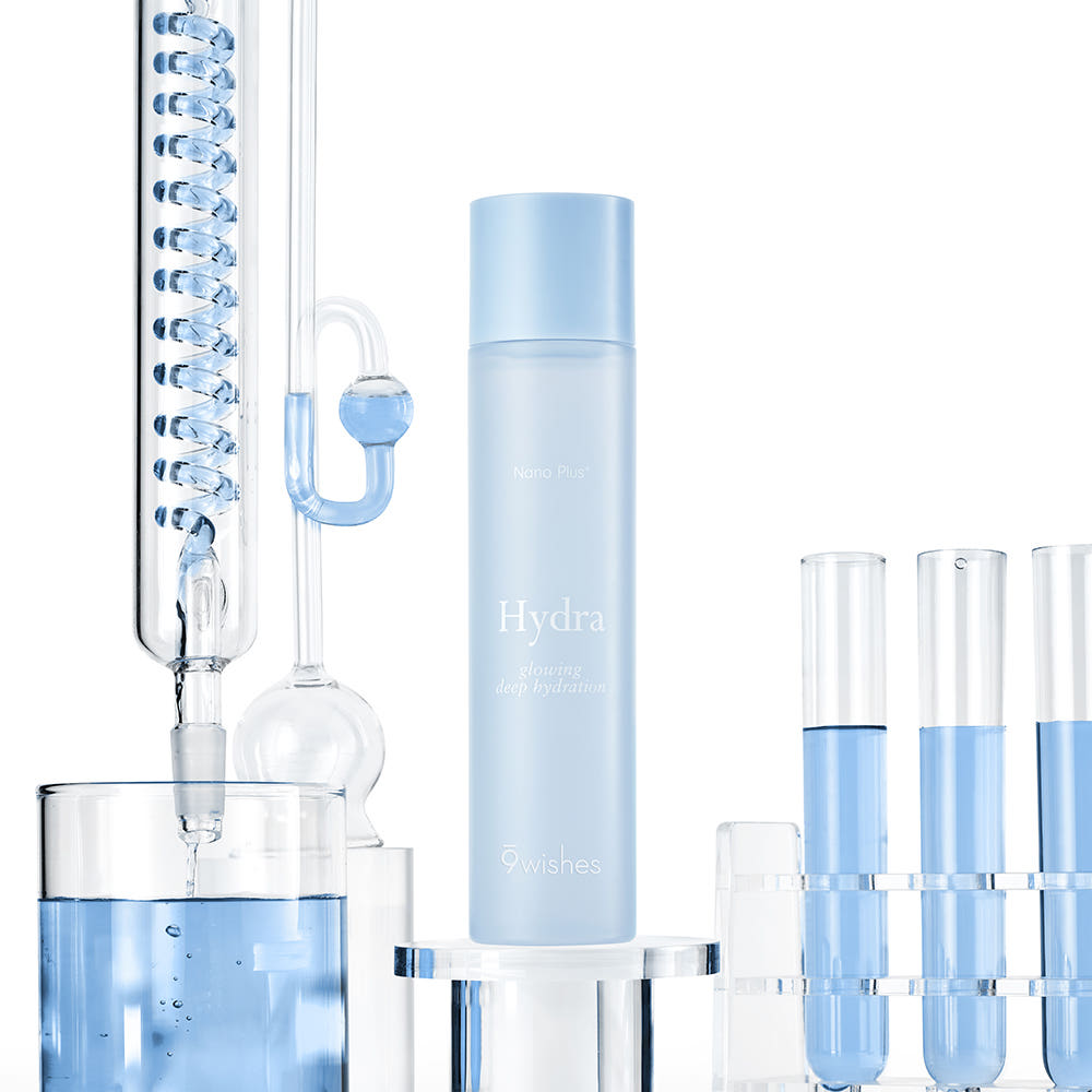 ProtoClinical k-beauty 9wishes Hydra Ampoule Toner Nano Plus+ 150ml three upright blue-gray containers on a pale cream background with soft blue lower accents