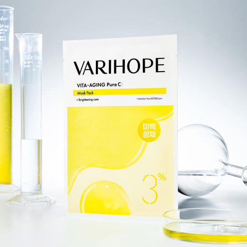 ProtoClinical k-beauty VARIHOPE: Vita-aging Pure C Mask Pack Ea (25ml x 5) bright yellow mask pack box standing upright over stacked boxes on a soft yellow background