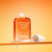 ProtoClinical k-beauty [By Wishtrend] Mandelic Acid Dark Spot Correcting Serum 30ml amber serum bottle with a white dropper and dripping serum on an orange background