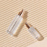 ProtoClinical k-beauty [DEAR DAHLIA] Endless Skin Setting Spray 30ml slim beige skincare bottle on a light background with warm neutral tones