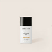ProtoClinical k-beauty warm beige beauty bottle silhouette with a charcoal cap on a soft ivory background.