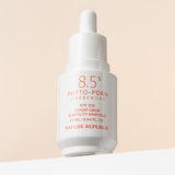 ProtoClinical k-beauty [NATURE REPUBLIC] Expert Drop Elasticity Ampoule 25ml upright ampoule bottle silhouette in warm gray on a light background with pale yellow side panels and soft pink lower accents