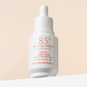 ProtoClinical k-beauty [NATURE REPUBLIC] Expert Drop Elasticity Ampoule 25ml upright ampoule bottle silhouette in warm gray on a light background with pale yellow side panels and soft pink lower accents