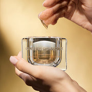 ProtoClinical k-beauty warm yellow beauty product detail with soft brown tones on a light background.