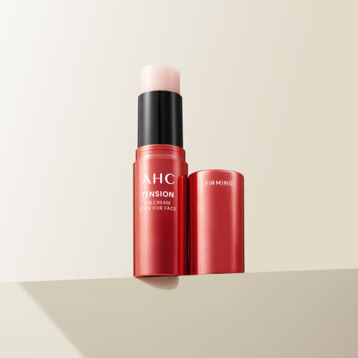 ProtoClinical k-beauty AHC Tension Eye Cream Stick For Face 10g single upright pink eye cream stick centered on a peach and cream background