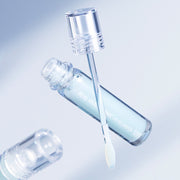 ProtoClinical k-beauty WELLAGE Real Hyaluronic Lip Plumper 3.8ml with a clear gloss bottle angled beside a wand applicator on a pale blue background