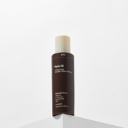ProtoClinical k-beauty tall dark cosmetic bottle on a light background with soft gray side accents.