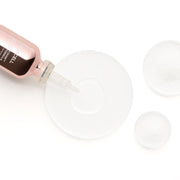 ProtoClinical k-beauty PURCELL 82% High Dose Peptide Formula 30ml shown as a tilted rose-gold serum bottle dispensing clear serum onto a translucent round dish on a white background
