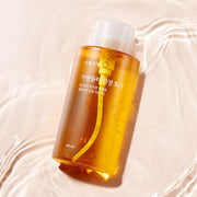ProtoClinical k-beauty Shingmulnara Calendula Calming Toner 500ml in a single centered upright packshot with warm amber tones and cool gray side shading on a pale beige background