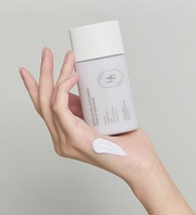 ProtoClinical k-beauty beige beauty bottle silhouette with a soft rose center on a light background.