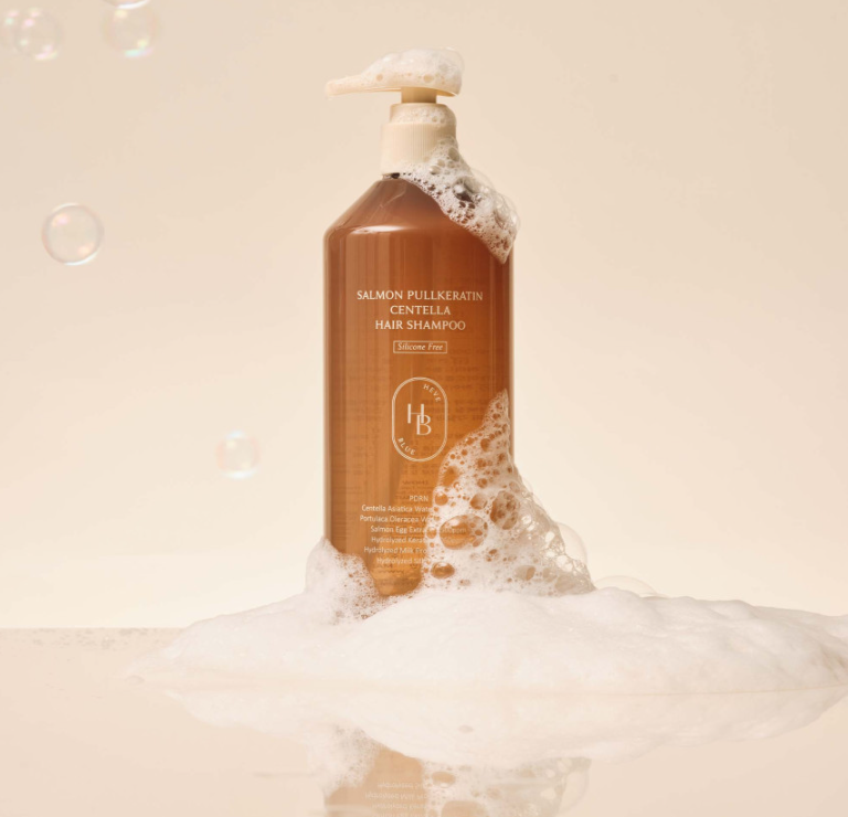 ProtoClinical k-beauty HEVEBLUE Salmon Pullkeratin Centella Hair Shampoo 500ml single warm brown shampoo bottle centered upright with pale peach side panels on a light background