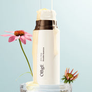 ProtoClinical k-beauty OBgE All in One Double Essence 100ml shown as a single upright beige-brown bottle centered on a pale background with light blue side accents.