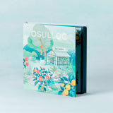 ProtoClinical k-beauty OSULLOC Tea Garden Gift Box Set (27 count, 9 flavors X 3ea) illustrated gift box standing at an angle with a visible spine on a pale blue background