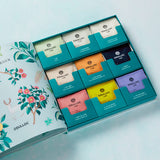 ProtoClinical k-beauty OSULLOC Tea Garden Gift Box Set (27 count, 9 flavors X 3ea) open gift box showing nine colorful tea compartments in a flat lay on a pale blue background