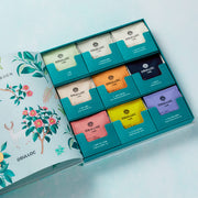 ProtoClinical k-beauty OSULLOC Tea Garden Gift Box Set (27 count, 9 flavors X 3ea) open gift box showing nine colorful tea compartments in a flat lay on a pale blue background