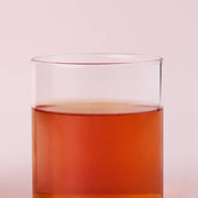ProtoClinical k-beauty warm orange beauty product silhouette with pale blue side panels on a light background.
