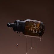 ProtoClinical k-beauty dark brown vertical beauty product silhouette on a warm beige background.