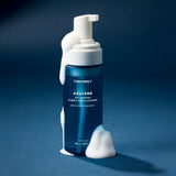 ProtoClinical k-beauty TONYMOLY Azulene Anti Blemish Bubble Foam Cleanser 150ml single upright blue cleanser tube centered on a dark blue background.
