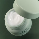 ProtoClinical k-beauty TONYMOLY Green Tea Moisturizing Cream 50ml single light green cream jar centered on a soft white and blush background.