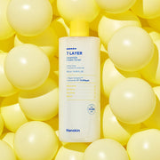 ProtoClinical k-beauty Hanskin 7 Layer Ceramide Cream Toner 500ml with a tall pale toner bottle centered between soft yellow side panels on a white background