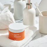 ProtoClinical k-beauty Hanskin Cleansing Balm & Blackhead 80g round brown cleansing balm jar near the lower left on a warm gray background with pale beige highlights.