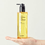 ProtoClinical k-beauty tall gold beauty bottle on a pale blue and white background.