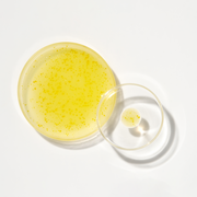 ProtoClinical k-beauty K-SECRET SEOUL 1988 GLOW SERUM : NIACINAMIDE 15% + YUJA 30ml as a single golden-yellow serum bottle centered on a pale blue and cream background