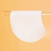 ProtoClinical k-beauty celimax Pore+ Dark Spot Brightening Pad 100ml/40ea translucent toner pad draped over a clear glass rod on a peach background