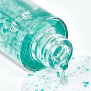 ProtoClinical k-beauty Anua PDRN Hyaluronic Acid Hydrating Capsule Mist 100ml close-up of the open bottle pouring clear gel with turquoise capsules onto a white surface