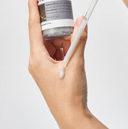 ProtoClinical k-beauty tan product bottle centered on a light background with blue side accents.