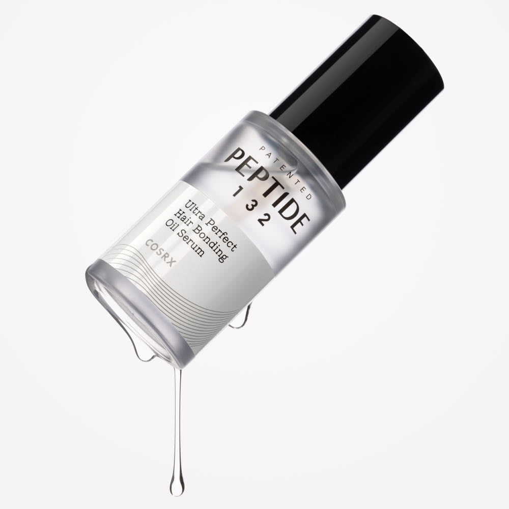 ProtoClinical k-beauty COSRX PEPTIDE-132 Ultra Perfect Hair Bonding Oil Serum 28ml tilted silver bottle with a black cap and clear serum dripping on a white background
