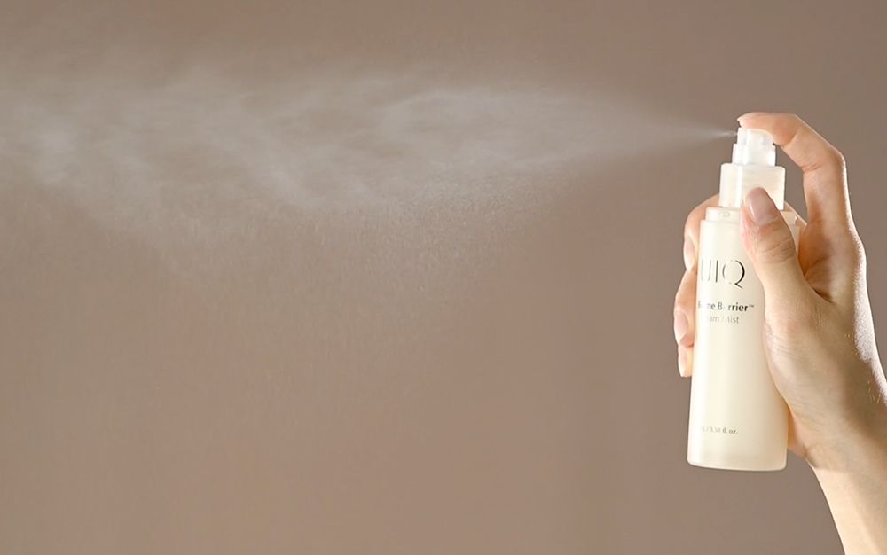 ProtoClinical k-beauty UIQ Biome Barrie Cream Mist 100ml with multiple frosted bottles, one open spray nozzle and loose caps arranged on a beige background