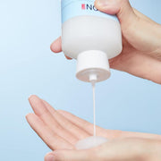 ProtoClinical k-beauty ILLIYOON Ceramide Ato Relief Skin Softener 250ml partially visible pale blue bottle dispensing milky toner into an open hand against a light blue background