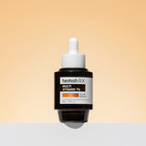 ProtoClinical k-beauty heimish RX Multi Vitamin Glow Serum 35ml single upright dark serum bottle centered on a light peach background with soft beige side shading.