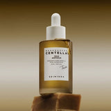 ProtoClinical k-beauty SKIN1004 Centella Teca Ampoule 50ml abstract beauty graphic with warm brown and taupe horizontal bands on a muted background.