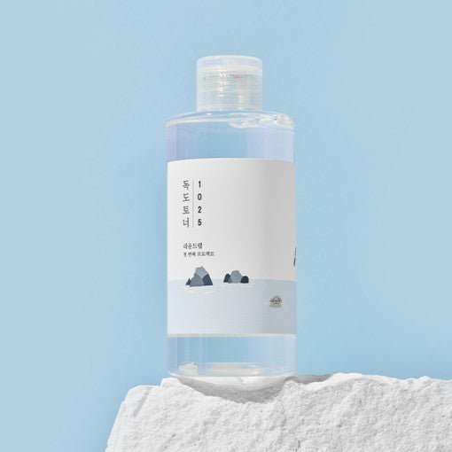ProtoClinical k-beauty Round Lab 1025 Dokdo Toner 200ml abstract beauty graphic with soft peach, aqua, and violet tones on a pale background