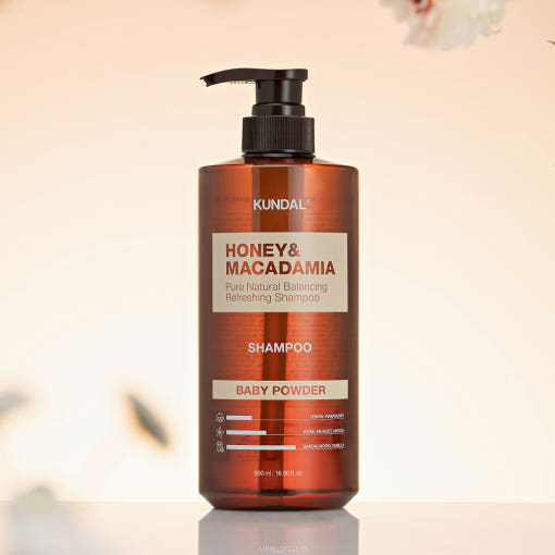ProtoClinical k-beauty KUNDAL HONEY & MACADAMIA Natural Shampoo (Baby Powder) 500ml single tall warm brown shampoo bottle centered on a soft cream background with pale green side accents.